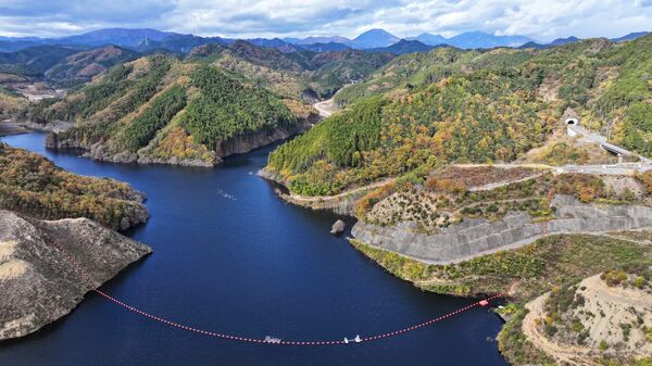 湛水開始から１年が経ち、水をたたえる南摩ダム＝18日午前11時55分、鹿沼市上南摩町、ドローンから