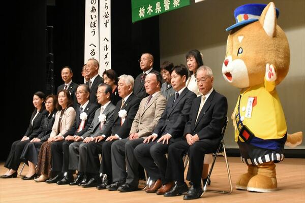 県交通安全協会のマスコットキャラクター「ちゃんと君」（右）と記念撮影する受賞者ら＝30日午後、宇都宮市文化会館
