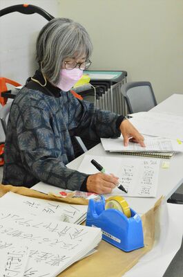 アナウンス原稿や選手名を書き写す筆談・要約筆記スタッフの安田さん＝26日午前、宇都宮市若草１丁目
