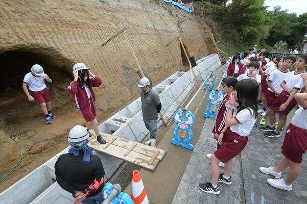 防空壕を見学する地元の子どもたち＝津市河芸町赤部