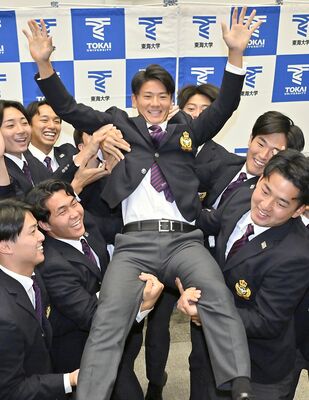 日本ハムから３位指名を受け、チームメートに胴上げされる東海大の大塚内野手（中央）＝23日午後６時35分、神奈川県平塚市の同大湘南キャンパス、広瀬華撮影