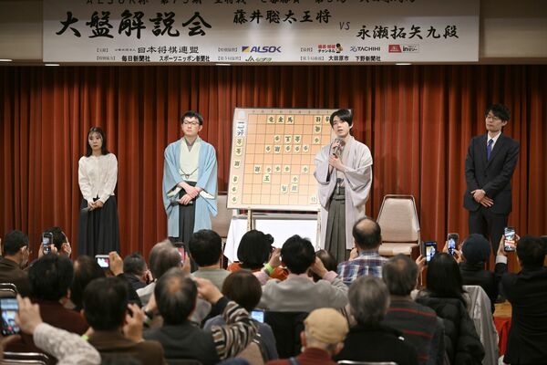 対局を終え大盤解説会場で挨拶する藤井王将（右から２人目）
