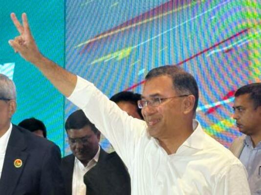 バングラデシュ・ダッカで記者会見後、ピースサインをするラーマン氏=14日(共同)