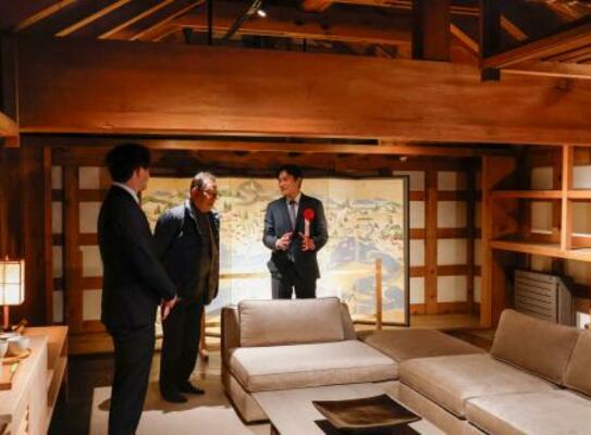 　「旧相馬家住宅」の蔵を活用した客室を案内する運営会社の他力野淳代表（右）＝２４日午後、北海道函館市