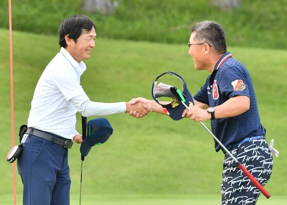 ＰＯ１ホール目で優勝を決めた植木（左）が秋澤と握手を交わす＝那須小川ＧＣ