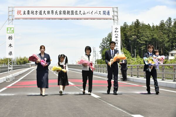 「三世代家族渡り初め」を行う鈴木浩文さん（左から４人目）一家