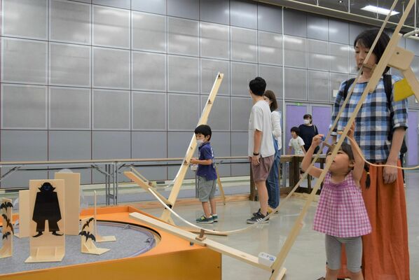 ビー玉を使った装置で遊ぶ子どもたち