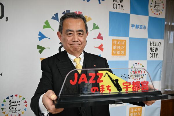 タクシーの上部に設置される表示灯を手にする鈴木代表取締役