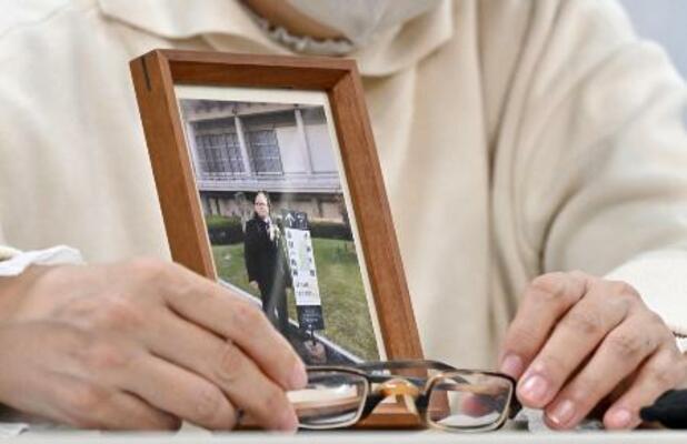 　赤木俊夫さんの写真と眼鏡を手に記者会見する妻の雅子さん＝２月、大阪市