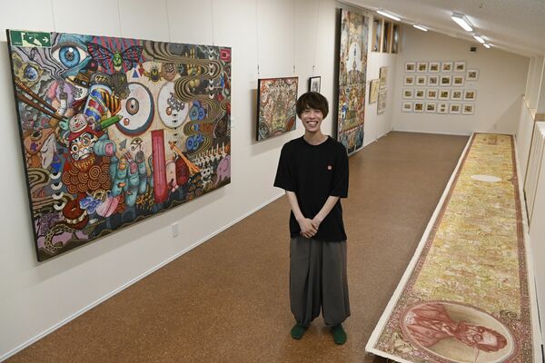 作品展を開いている飯山さん。多彩な絵が会場を彩っている
