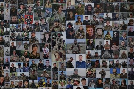 　ロシア侵攻後に犠牲になったウクライナ兵士らの写真。修道院の外壁に掲示された＝23年２月、キーウ（共同）