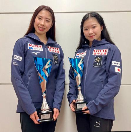 フィギュアスケートのロンバルディア杯で獲得したトロフィーを持ち、ポーズをとる優勝した住吉りをん(左)と2位に入った中井亜美=15日、羽田空港