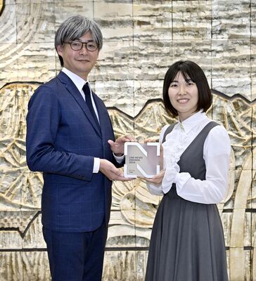 ＬＩＮＥヤフーの大塚氏（左）からトロフィーを受け取る下野新聞社の担当者