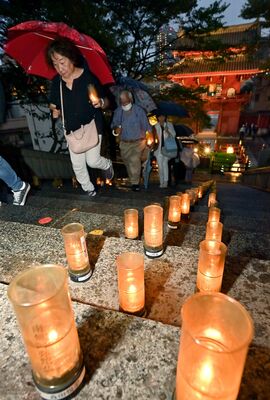 慈光寺の石段にずらりと並べられた燈明＝16日午後６時50分、宇都宮市塙田１丁目