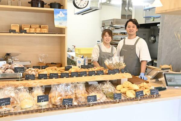 数多くの商品が並んだ店内に立つ早坂さん夫婦