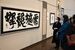日賀野琢代表の作品（左）を鑑賞する来場者