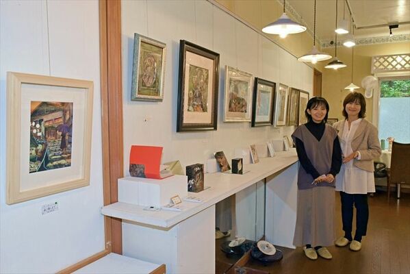 画家５人の作品が並ぶ会場に立つ小原さん（右）と宮本さん
