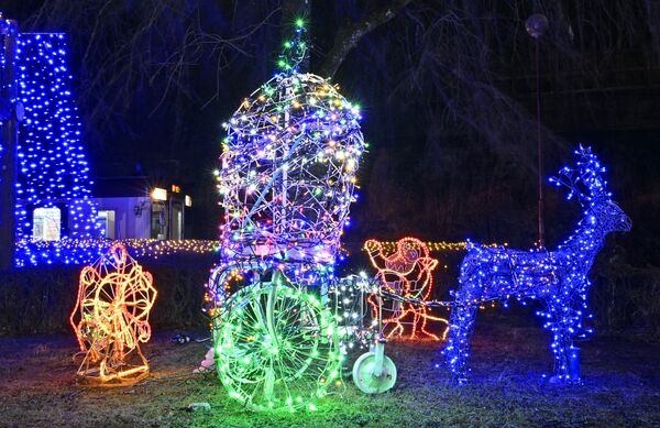 イルミネーションに彩られた間藤駅とわたらせ渓谷鉄道の列車（左奥）＝26日午後７時45分、日光市足尾町下間藤