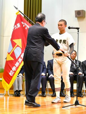 船田学院長（左）から選抜旗を受け取る作新の小森主将＝作新高聴蛙館