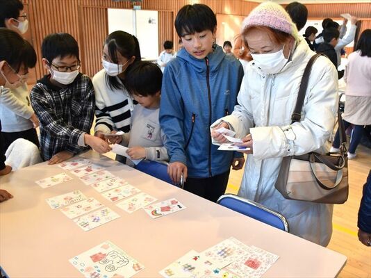 生産した絵はがきを販売する子どもたち