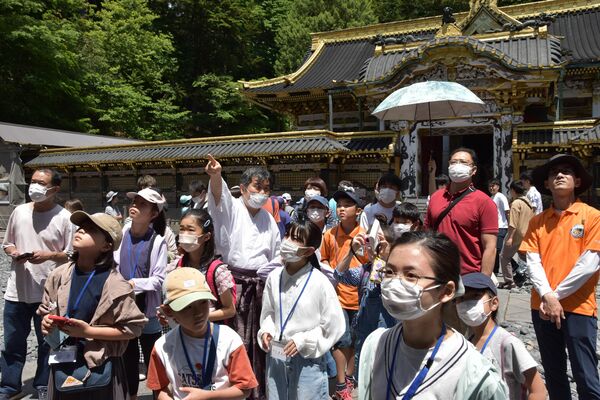 東照宮担当者の解説を聞きながら境内を見学する参加者
