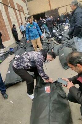 イラン・テヘラン郊外で9~11日にかけて撮影された動画の中で、遺体の身元を確認する人々(ソーシャルメディアから、AP=共同)