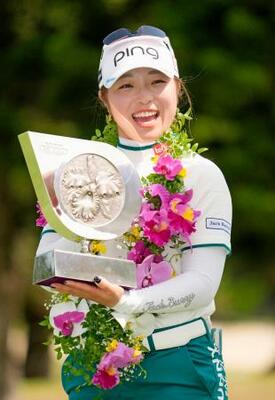 通算16アンダーで優勝し、笑顔でトロフィーを手にする佐久間朱莉=琉球GC
