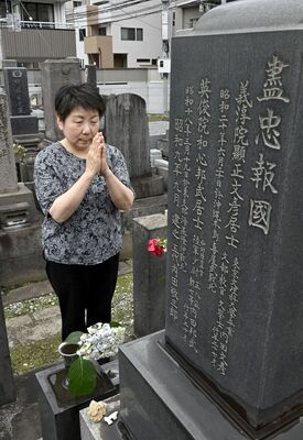 伯父の墓前で手を合わせる内田典子さん＝12日午後２時10分、宇都宮市南大通り４丁目