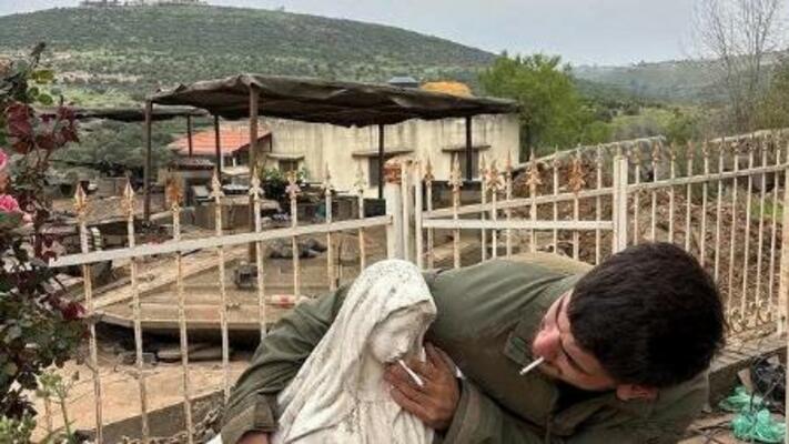　聖母マリア像にたばこを押しつけるイスラエル軍の兵士（ソーシャルメディアから、ロイター＝共同）