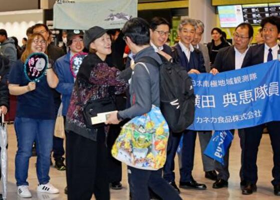 成田空港に到着し家族らと再会する南極観測隊の隊員(手前右)=25日午前