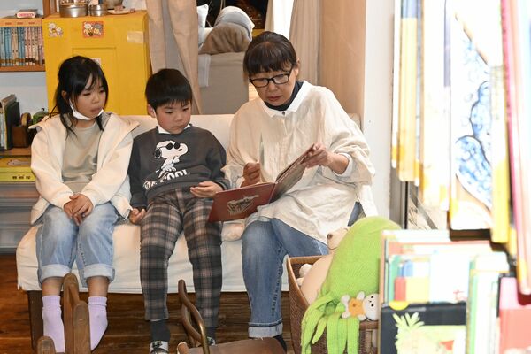 石川さん（右）の読み聞かせに耳を傾ける子どもたち