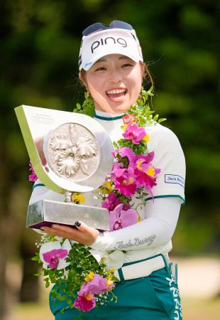 　通算１６アンダーで優勝し、笑顔でトロフィーを手にする佐久間朱莉＝琉球ＧＣ