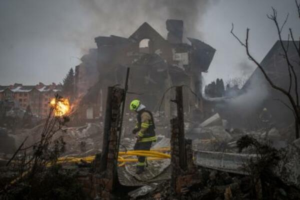 22日、ロシアの攻撃があったウクライナ首都キーウ近郊で緊急対応に当たる隊員。ミサイルや無人機攻撃が相次いでいる(ゲッティ=共同)