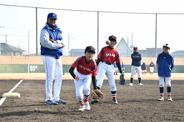 選手（左）の指導を受けながら守備練習に取り組む子ども