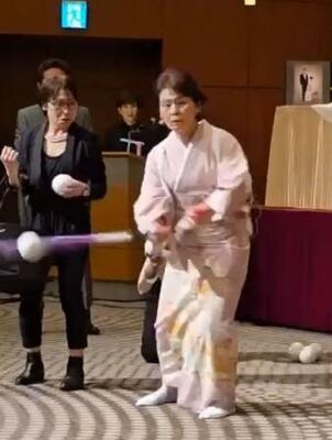 着物姿でノックを披露する宇津木妙子さん(右)=9日、東京都内