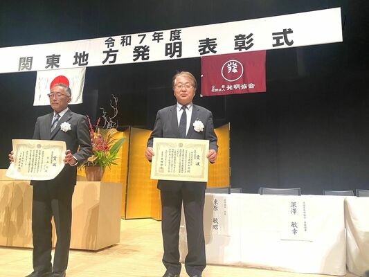 実施功績賞の賞状を持つ西堀和男社長(右)
