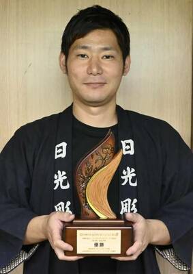 制作したトロフィーを持つ大島さん