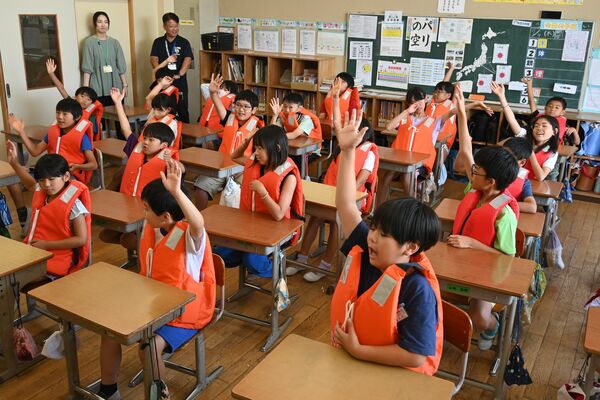ライフジャケットを着て出前講座を受ける児童