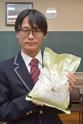 「ゆりがね米」のパッケージを手にする金山さん