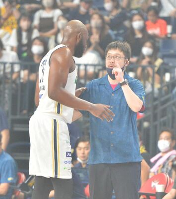 秋田のチームカラーであるピンク色のシャツを着て指揮を執るブレックスの佐々監督（右）＝沖縄アリーナ