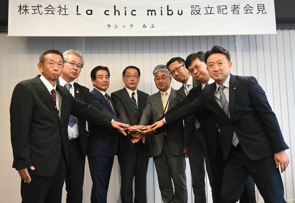 「ラシックみぶ」の設立で手を重ねる出井社長（中央）ら