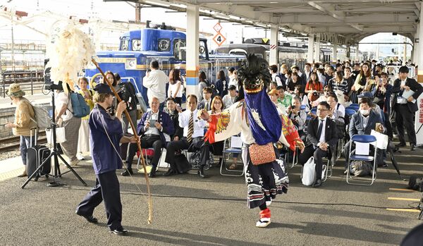 「会津彼岸獅子」の獅子舞で出迎えられるＳＬ大樹「土津」の乗客ら＝27日午後５時10分、会津若松駅