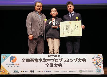 　「２０２５年度全国選抜小学生プログラミング大会」でグランプリの文部科学大臣賞に選ばれた岡山県代表の山下桃子さん（中央）＝８日午後、東京都港区