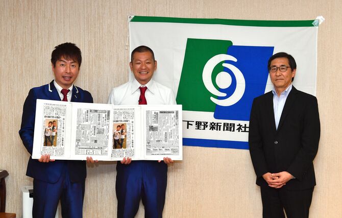 若菜社長(右)から誕生日の紙面を載せた「記念日新聞を受け取るU字工事=5月22日午後3時10分、下野新聞社本社