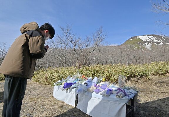 那須雪崩事故の現場を望む献花台で手を合わせる関係者＝２７日午前８時４５分、那須町湯本