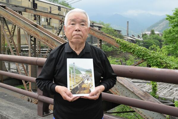 「親子三代足尾に生きて」を手にする上岡さん