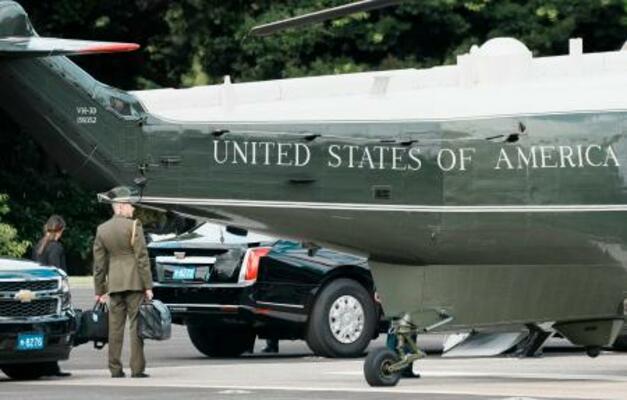 トランプ米大統領を乗せた大統領専用ヘリ、マリーンワンのそばで「核のボタン」とみられるかばんを持ち待機する米軍関係者=29日午前、東京都港区の赤坂プレスセンター