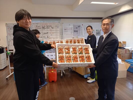 関事務局長(右)にイチゴを手渡す石川さん(左)