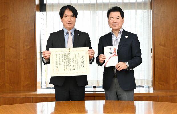 市から贈られた感謝状を手にする藤尾社長（左）と佐藤市長