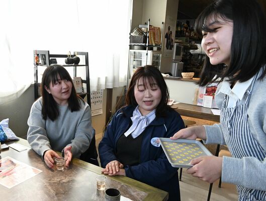 カフェの利用者にイチゴ酢の試飲を勧める栗原さん(右)